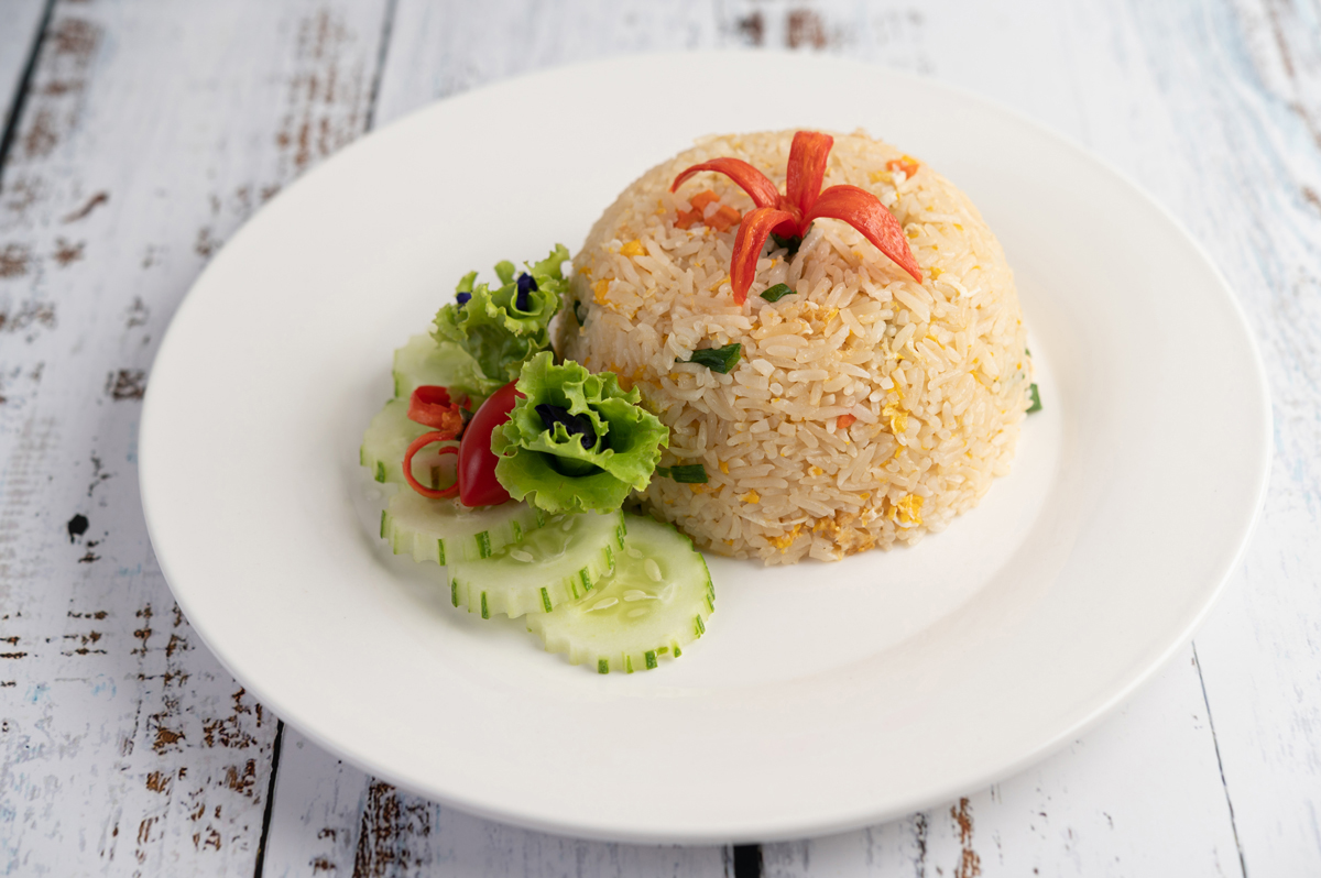 fried rice with eggs white plate wood surface